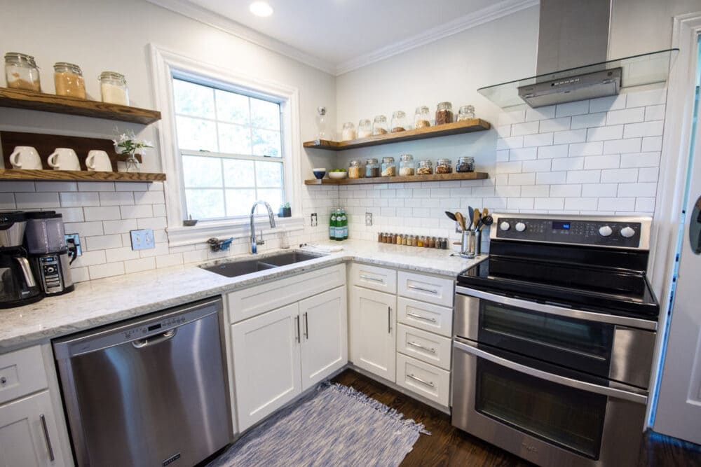 White Kitchen with Stainless Steel Oven and Dishwasher and Marble Countertop