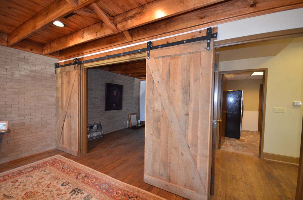 Sliding Door in Front of Rug with Black Fridge in Next Room