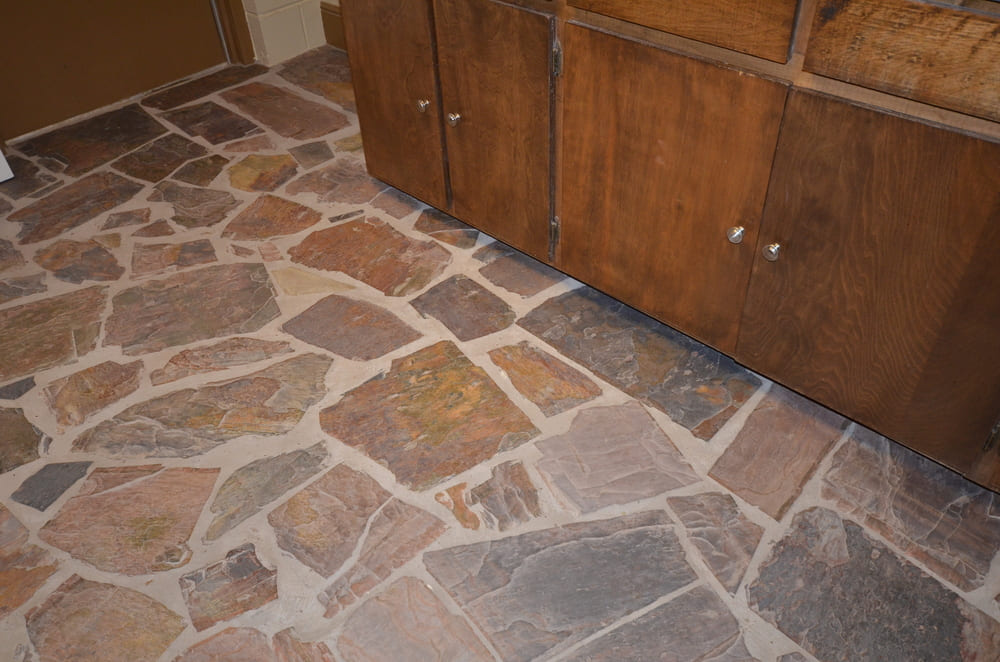 Stone Floor Next to Dark Wood Cabinets