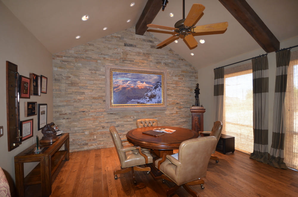 Small Round Office Table Near Brick Wall and Large Mountain Painting