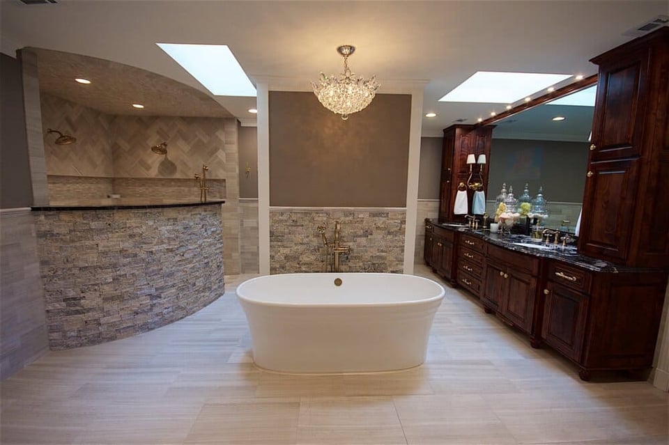Freestanding Tub in Bathroom Next to Stone Backsplash