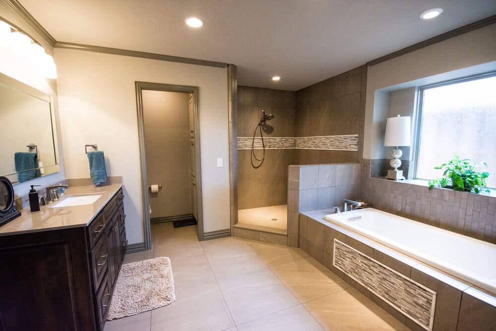 Bathroom with Tile Floor and Rectangle Bathtub Next to Bright Window