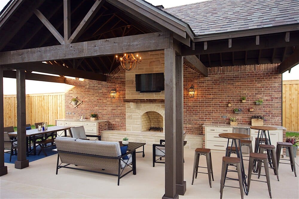 Outdoor Living Space with Comfy Couch and Television Mounted on a Brick Fireplace