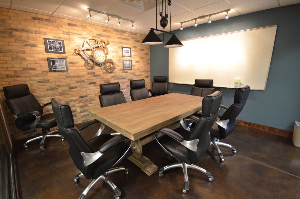 Meeting Table with Black Rolling Office Chairs and Large White Board