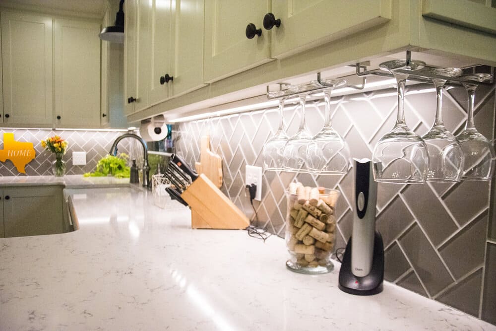 Marble White Countertop with Cooking Knives, Corks, And Dark Faucet