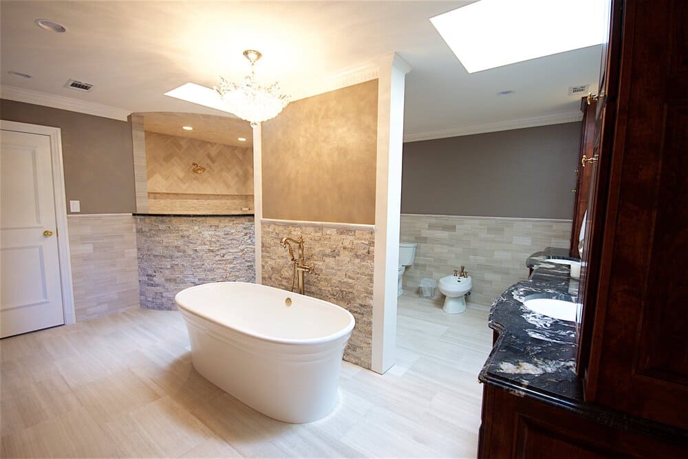 Freestanding Tub in Lightly Lit Bathroom with Stone Backsplashes