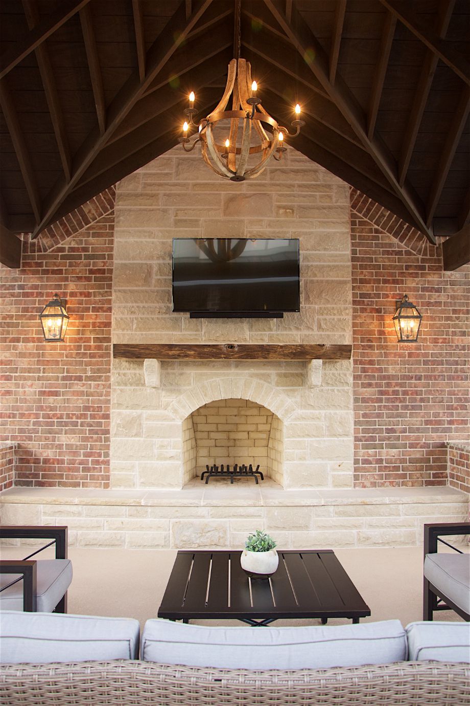 Outdoor Fireplace in Rustic Entertainment Center Featuring Brick and Lanturn